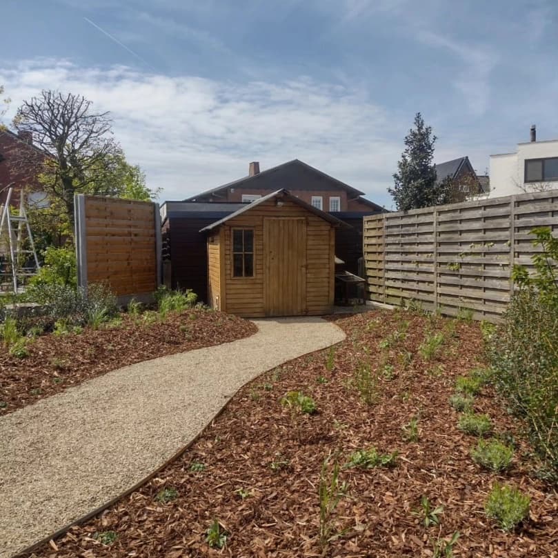 Achtertuin met tuinhuis, grindpad en vers gemulchte borders